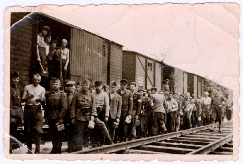 Romanian Jews from a forced labour group beside a train